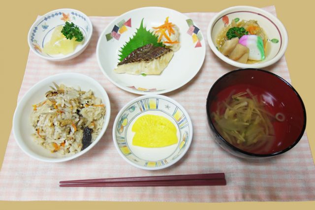 介護施設の食事。刺身、炒飯、野菜など栄養バランスの取れた一汁五菜の献立